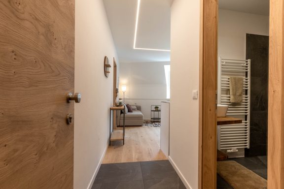 Sanierter Flur mit Holztüren, klaren Linien und modernen Bodenbelägen