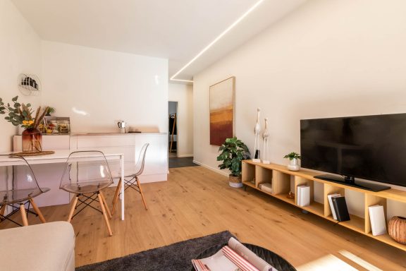 Wohnzimmer mit TV-Board, Pflanzen und warmen Materialien