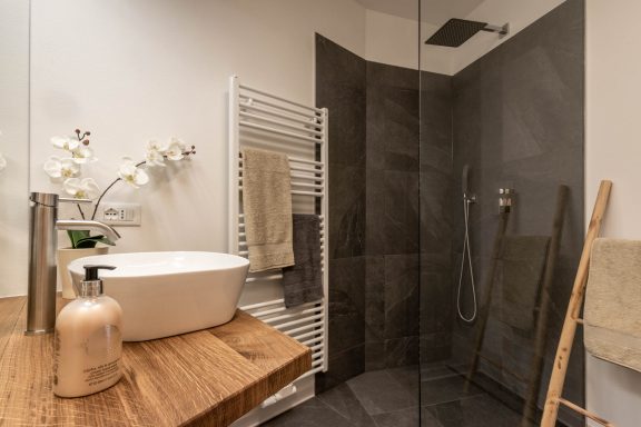 Walk-in-Dusche mit Glasfront und grauen Natursteinfliesen