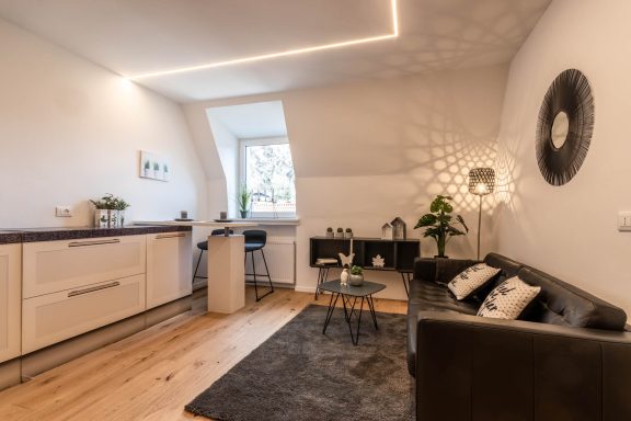 Heller Wohnbereich mit Sofa, Essplatz und stimmigem Beleuchtungskonzept